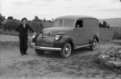 Mann ved sida av en varebil. Mannen er ikke identifisert, me