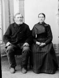 Portrett, eldre ektepar sittende i atelier.