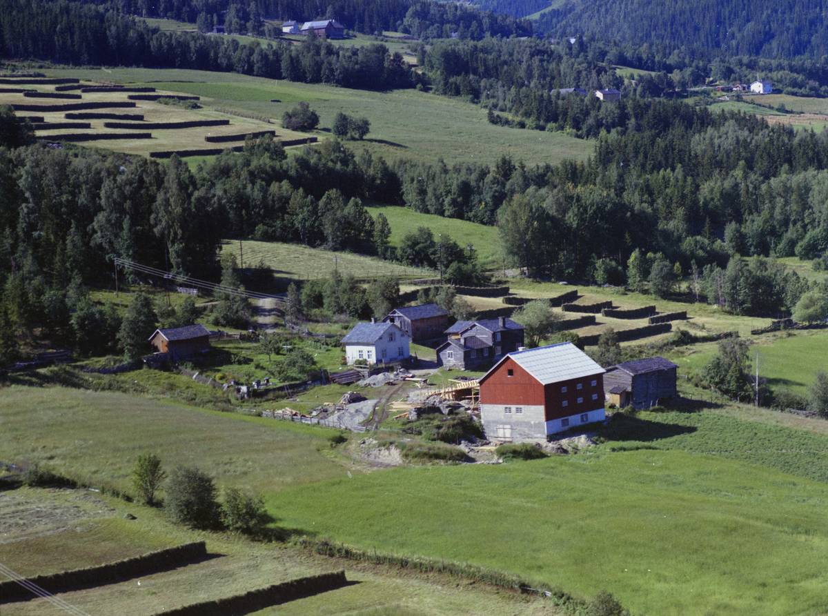 Olstad nordre (nordistugu), gårdsbruk, gamle hus, ny låve med låvebru under bygging.