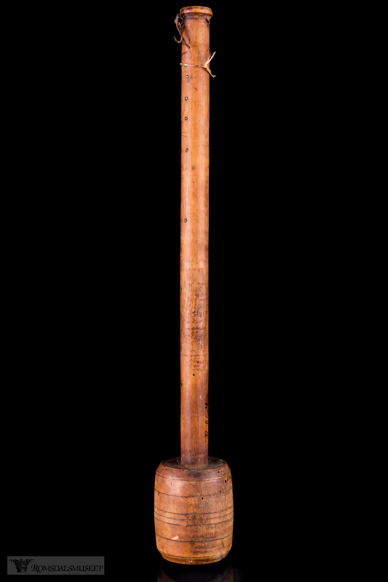 Dreid sylindrisk hode med avrundet skaft og innsatte messingstifter som målemerker.