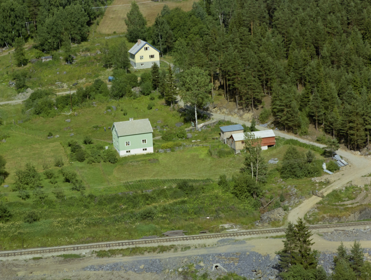 Sør-Fron, Harpefoss, Øvrevoll. Et grønt hus og et gult hus, kjøkkenhage, jernbane, skog,