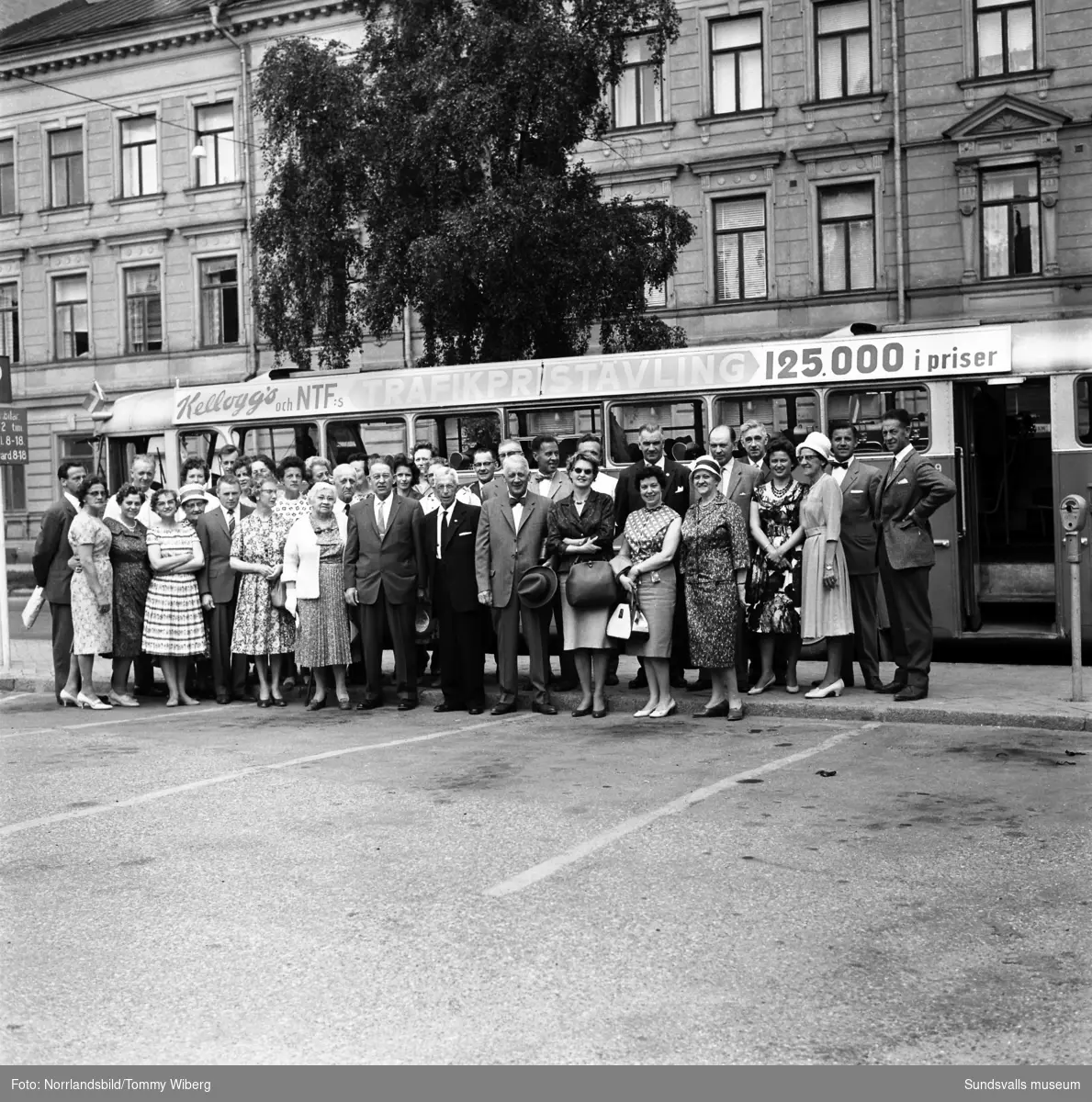 En grupp svensk-amerikaner poserar framför bussen på Köpmangatan vid Nytorget inför en resa till Österström.