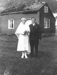 Ukjent brudepar foran gammelt hus.