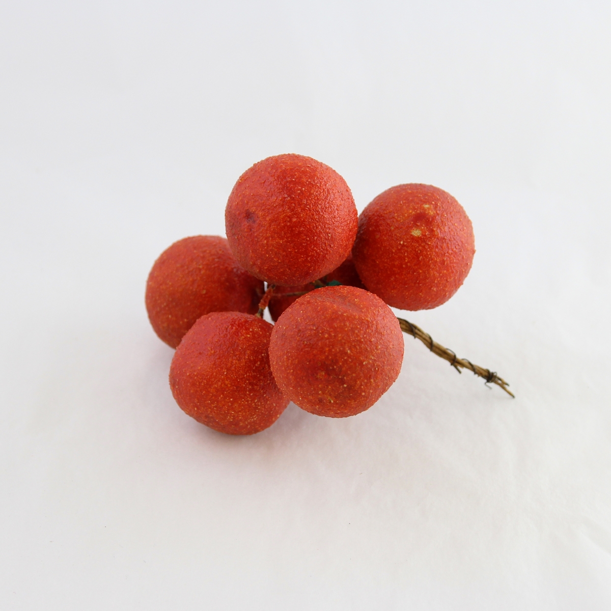 Dekorasjon: 6 røde kuler på grein: modell av frukt/bær.