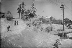 Barn på ski i Hvåladalen. Sentrumsskolen sees i bakgrunnen.