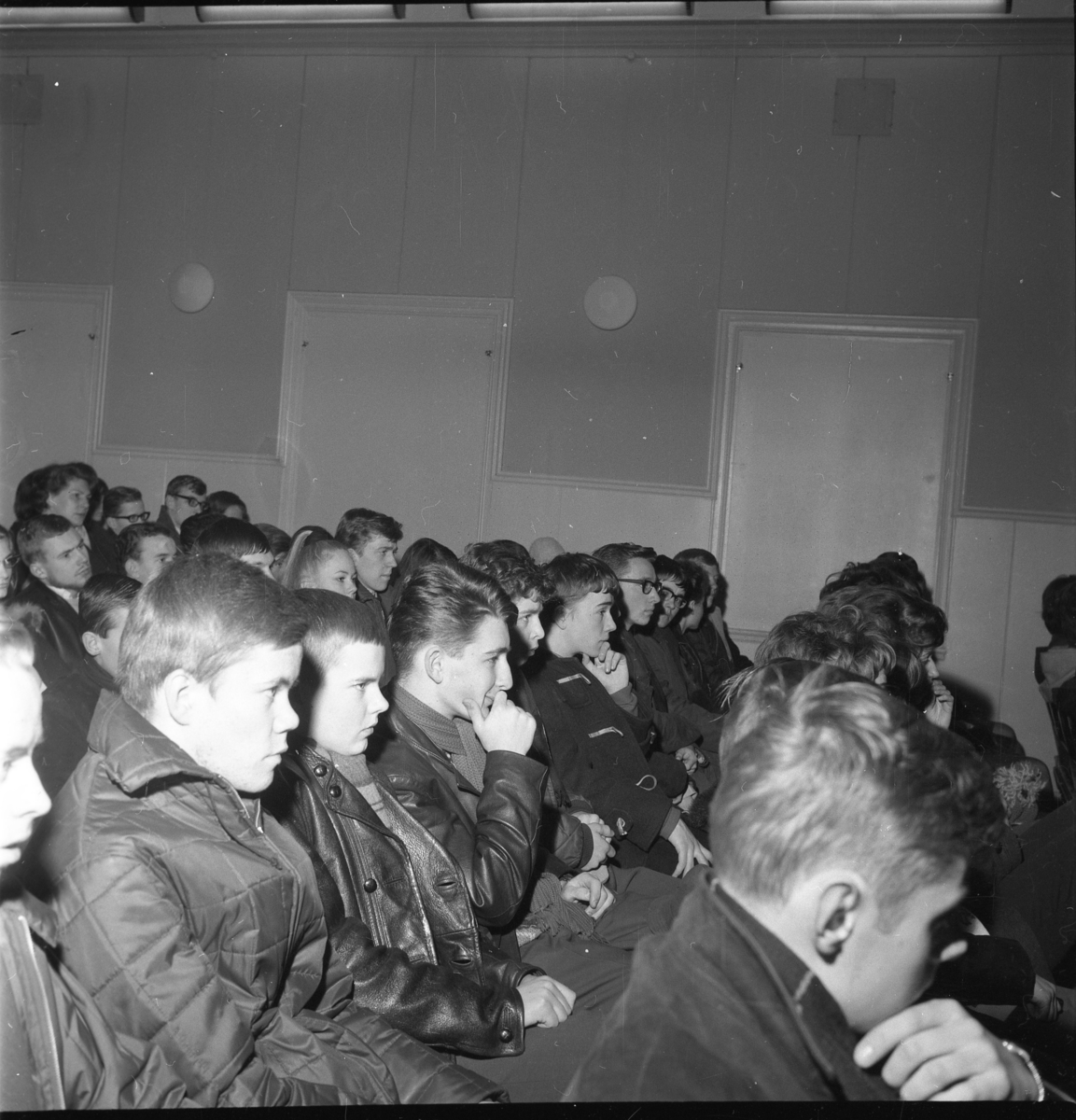 Ung publik från Gränna realskola i Grännaskolans matsal som lyssnar på Arne Domnérus orkester i februari 1964. I andra raden fr vänster sitter Sigvard Jarl som nummer två, därnäst Sven-Åke Wadskog, Göran Malm, Christer Andersson och Gösta Ekman och sjua är Håkan Grennwall. Flickan med hästsvans i raden bakom är Marita Wallmo, på hennes vänstra sida sitter Per Lilja. I vänstra hörnet sitter också bland andra Lars Aspgren, Mrs Janes, Claes Jerneck och Anders Thörnblad.