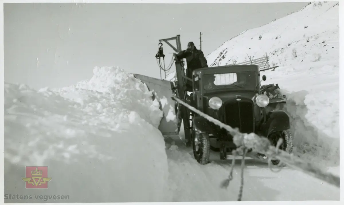 "Sideplog i arbeid ved Nystuen 1935", i følge merking på baksiden av bildet.  Lastebilen har rømmeving som trekkes med tau av lastebilen foran. Ref. til illustrasjon i artikkel fra "Meddelelser fra Vegdirektøren", Nr. 4-1937. Artikkel om "Brøyting på Filefjell, av Hans Wangensten Paus. Se vedlegg i nedlastinger. 

Bilde 2) Bilen er en 1934 modell Federal med kjennetegn E-3556.  I 1935  eies den av A/S Jotunheimen og Valdresruten Bilselskap. 
Fotonr. NVM00F32094.