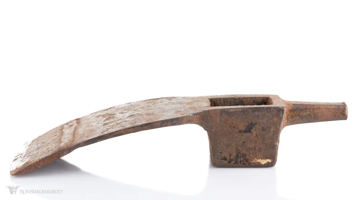Øksehode med eggen på tvers i forhold til skaftefestet. Rett egg som ser ut til å ha blitt smidd på av bruker. Hammer med firkantet snitt i bakkant av hodet som smalner av mot enden. En tverrøks brukes til å hugge stokker og planker for å jevne ut flater, forme bjelker og takrygger samt ved snekring og båtbygging.