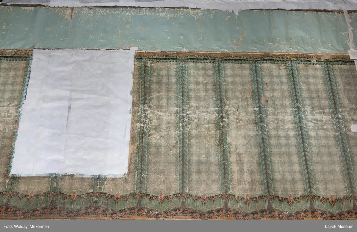 |Tapeten er påmalt tapetborder og brystning. Fra Hovland gård i Larvik.
Den øverste, brede borden: Gerlander/draperi med blomsterranker.
Den nederste, smalere borden: Tekstilbord med blomster. Øver døren til høyre: Stillebenmotiv med blomster og frukt.