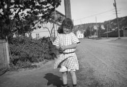 Pike i sommerkjole i småby muligens  i Oslofjordområde.