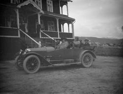 Bil med folk utenfor Grotli Hotell.