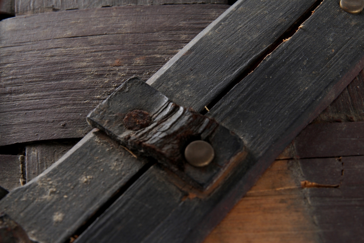 Brunmalt korg flettet av spon. En stor rund hank på midten og to lokk. Bare det ene kan åpnes.