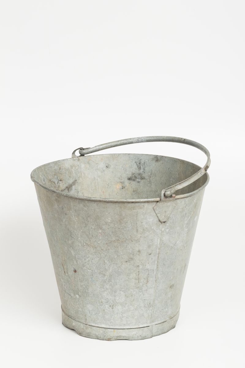 Grå metallbøtte med hank. Sotflekker på innsiden.