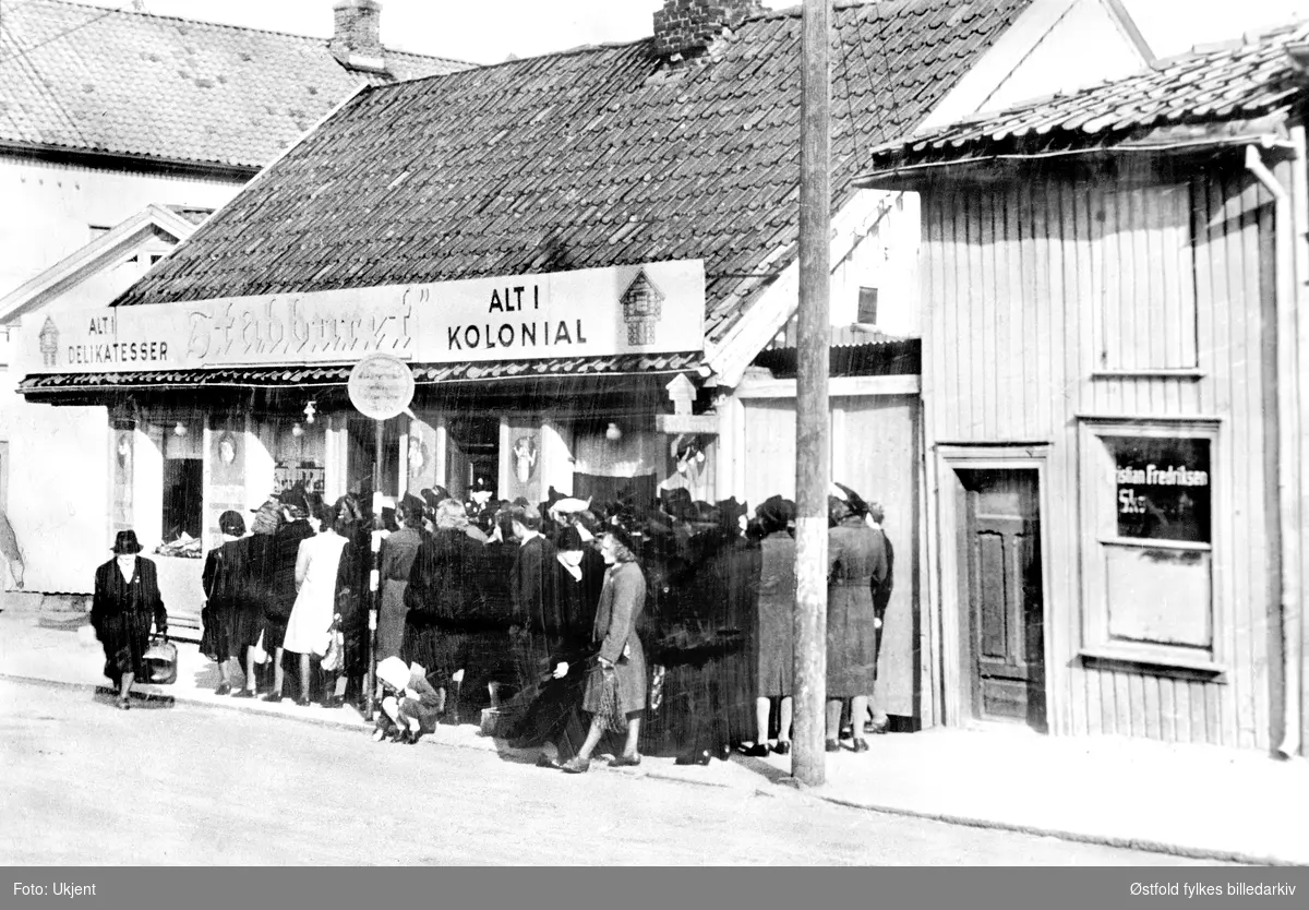 Kø utenfor kolonialbutikken "Stabburet" i Brochs gate, Fredrikstad 1942, under andre verdenskrig.
