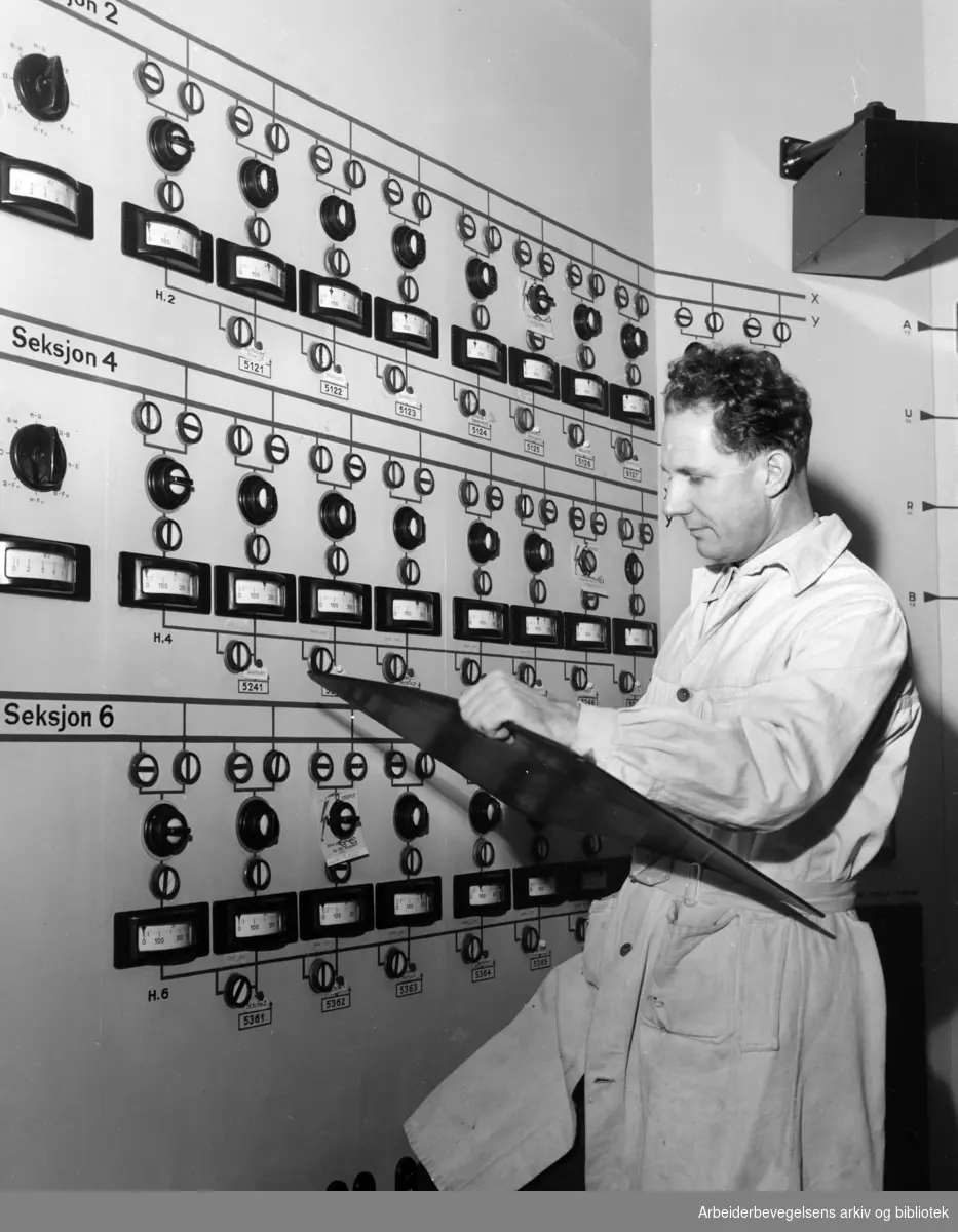 Smestad transformatorstasjon. Samkjøringssentralen. Odd Olsen foran instrumenttavla. Desember 1954