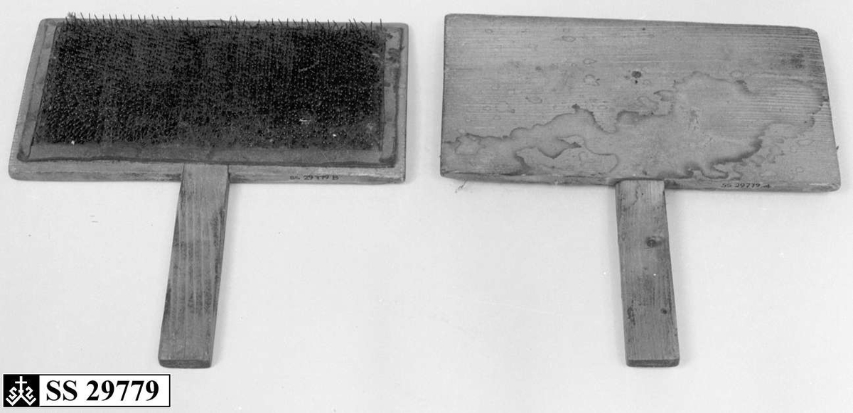 To treplater hvor innsiden av begge platene er dekket av en skinnduk med tettsittende nåler. Begge treplatene har håndtak.