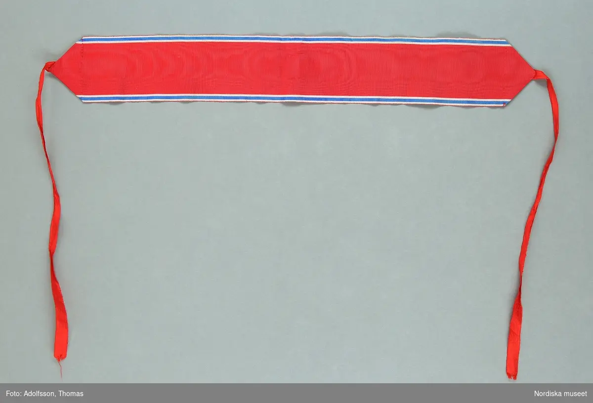 Huvudliggaren:
"a-e, Ordenstecken, ordensband, 5 st, St Olavsorden (Norge); röd vattrad sidenrips med smala vita och blå ränder. Br. a) 4 cm, b-e) 5,7 cm; L a) 43 cm, b 26,5 cm, c) 72 cm, d) 42 cm, e) 41,5 cm.
Tillhört överintendenten och kabinettskammarherren Fritz von Dardel (1817-1901) ; Bil=förteckning.
G.  13/3 1967, Överdirektör Fredrik von Dardel, Djursholm."