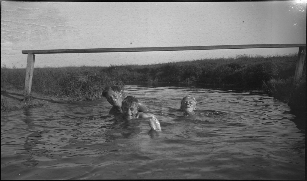 En stor vennegjeng i lystig lag på stranda på Sola. De har trommer og trekkspill og leker i vannet og på land med og uten ball. Sola strandhotell ligger i bakgrunnen. Tor Johannessen og Harald Bergsaker er på bilde nr. 14 og 18.