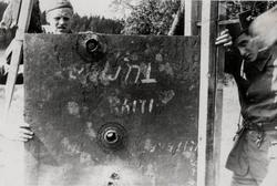 Soldater viser frem en gjennomhullet stålplate.