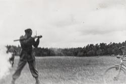 Soldat avfyrer en Panzerfaust. Forhjul og styre på en sykkel