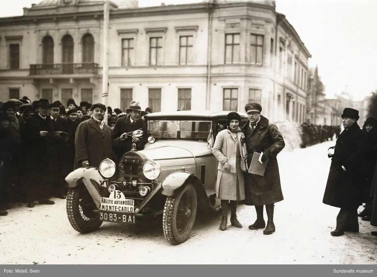 Monte Carlo-rallyt med start från Nytorget en januaridag 1930. Källarmästare Oscar Knaust med tävlingens yngsta deltagare, 18-åriga mademoiselle Renée Friéderich, med sin Bugatti. Renée var dotter till den kände racerbilsförararen Ernest Friéderich som även var anställd på Bugattifabriken. Bilen finns bevarad än idag (2020).