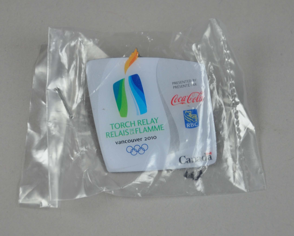 Pins med logo for Fakkelstafetten i forbindelse med OL i Vancouver i 2010. Det er også en Coca-Cola-logo og en logo med innskriften RBC på pinsen.