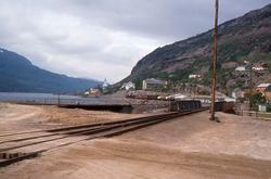 Lomi stasjon med bru over Giken elv og tog som har forlatt s