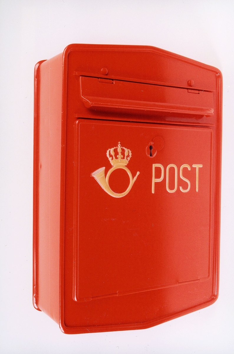 Rød, manuell tømmepostkasse med posthorn og ordet POST. Låsbar. Uten angivelse av tømmetider.