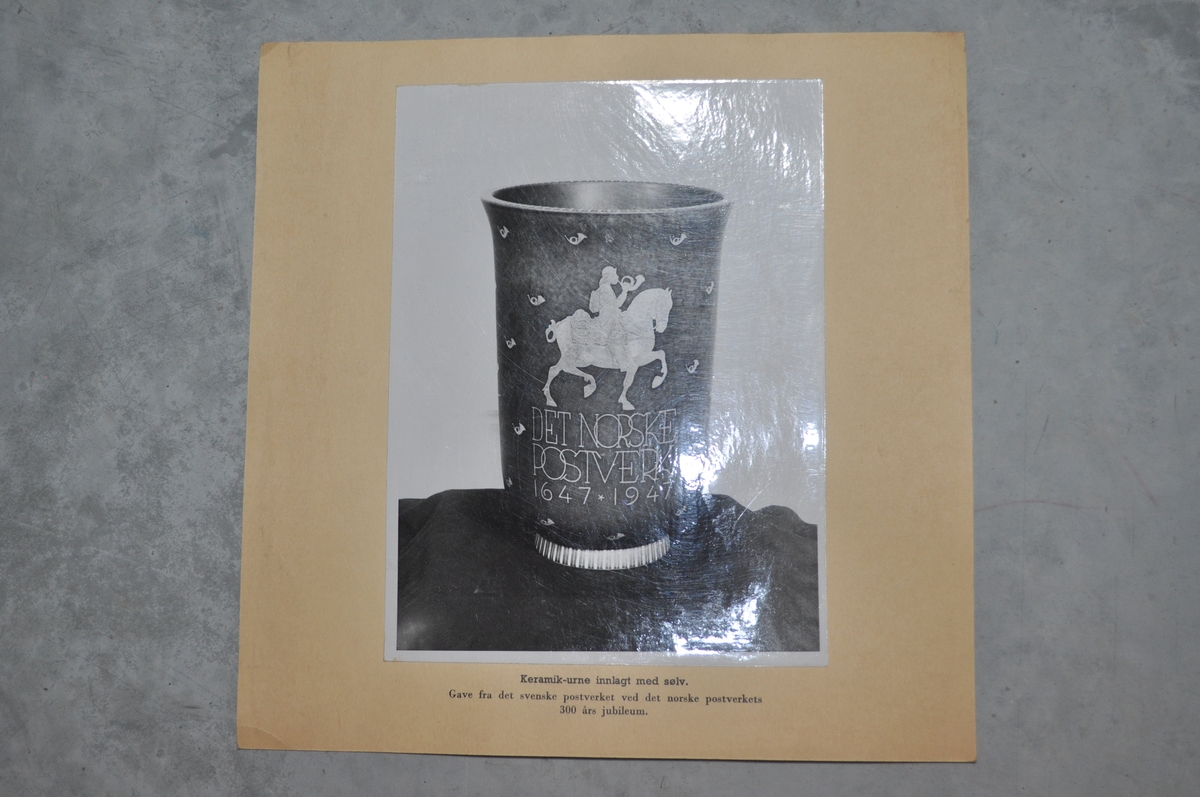 Bilder av framside og bakside av en urne som er gitt av Svenske Postverket i forbindelse med Postens 300 års jubileum.