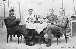 Fire menn i kortspill og med noen gode flasker med noe godt 