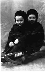 Portrett av to smårollinger på kjelke