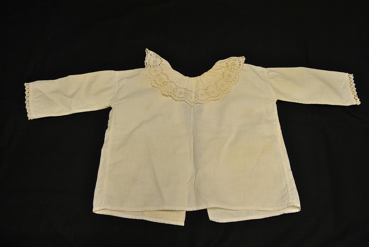 Barnetrøye med blondekrage og nuppereller på ermene. Noe gulnet og flekkete.