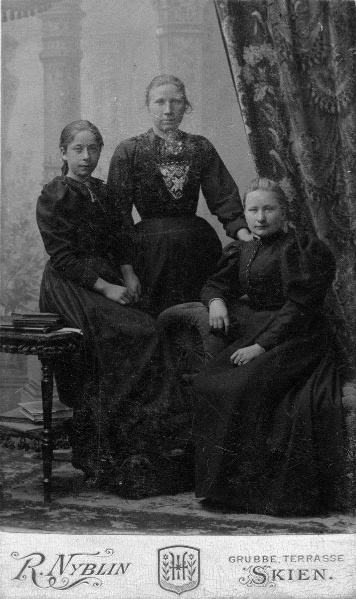 Tre kvinner.  Portrett av Milla Venke Bergan og to andre kvinner i fotoatelier.