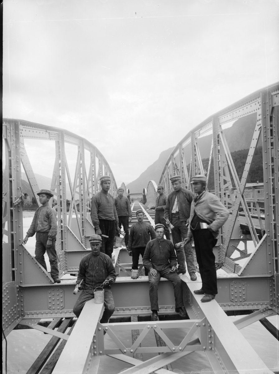 Jernbanebru,fagverksbru i stål,  over Otta elv ved Otta under bygging. Malingsarbeider utføres av 9 mann.