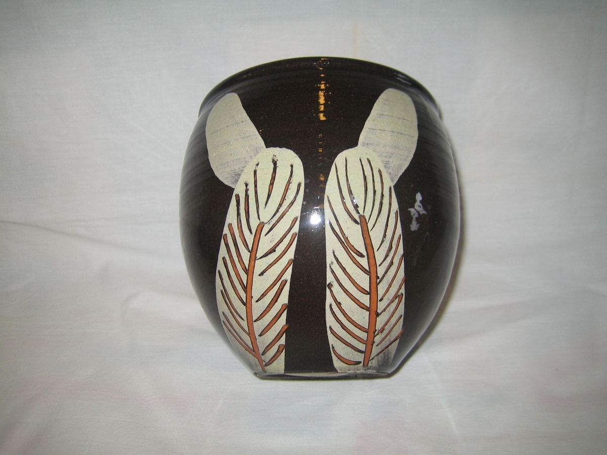 Kruka/vas i svartglaserd keramik dekorerad med fjädrar i vitt och orange