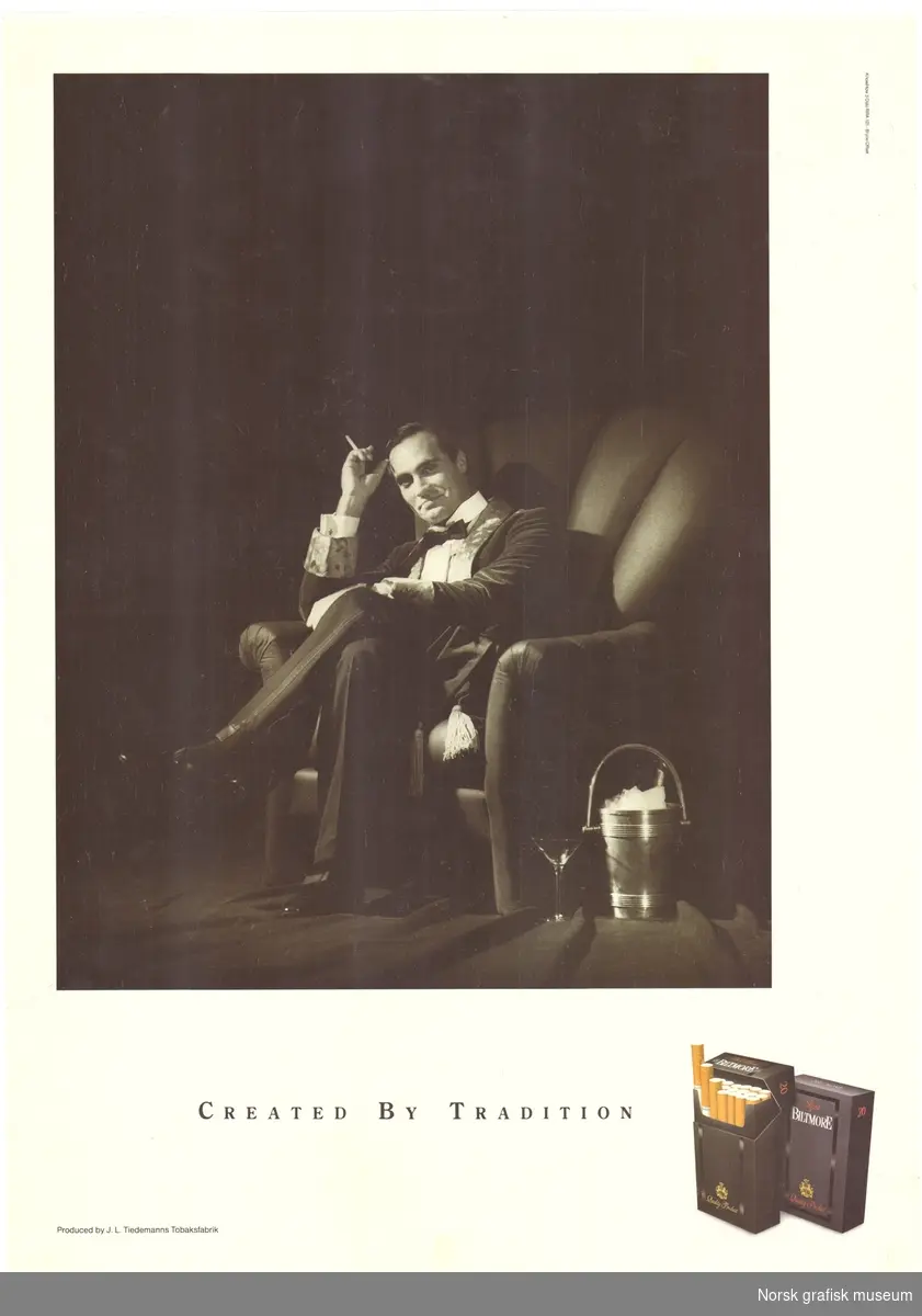 Reklameplakat for sigaretter av merket "Biltmore" fra J. L. Tiedemanns Tobaksfabrik.
Motiv i sort/hvitt, en mann kledd i kjole og hvitt sitter i en lenestol med en champagnekjøler ved siden av. 
Tekst: "Created by tradition".