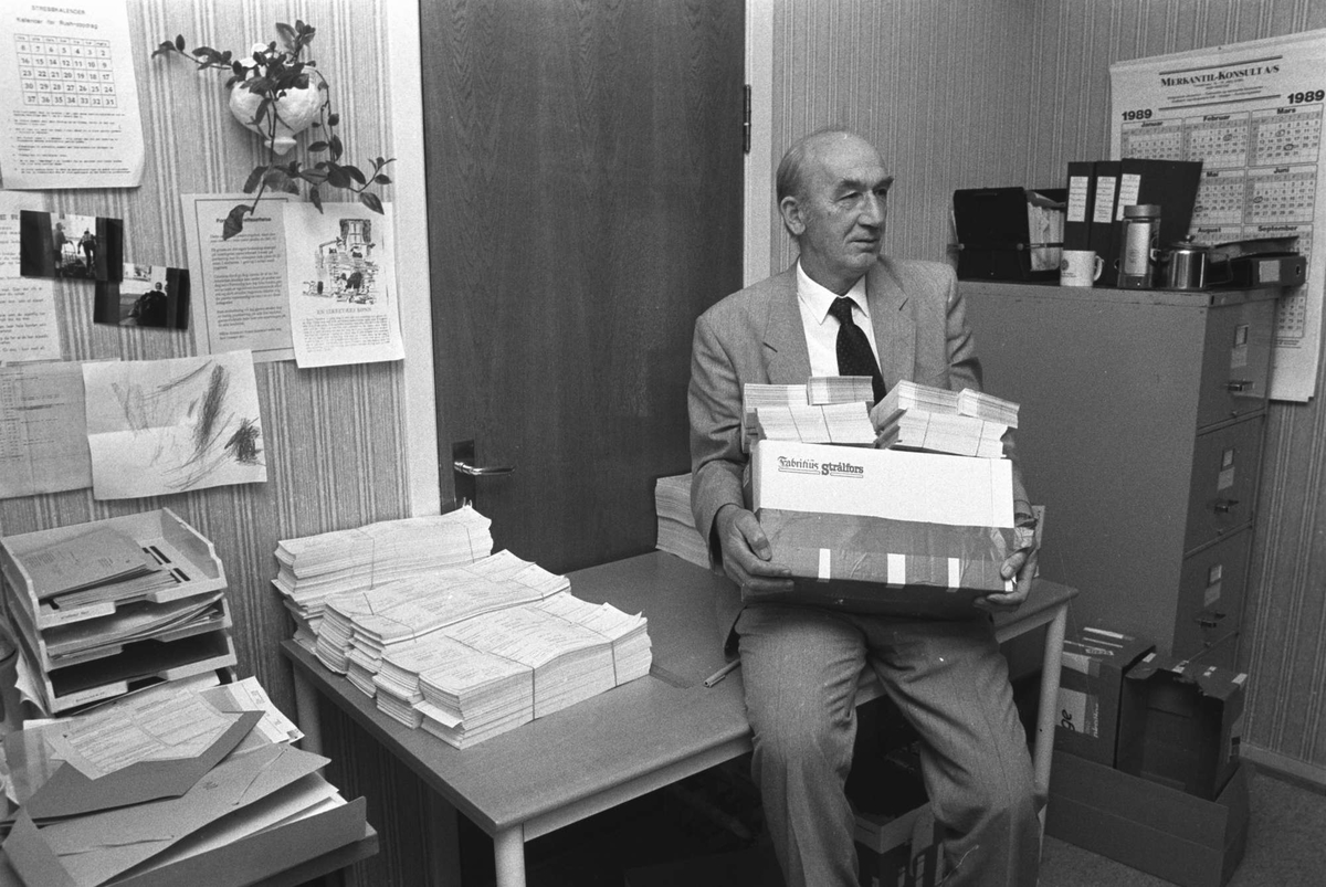 Bykasserer Arnold Aronsen på kontoret med en eske full av skjemaer.