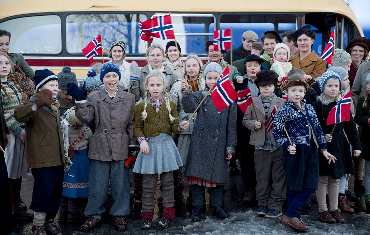 Langs jernbanesporet blir kongens tog hyllet med norske flagg. Alvoret har ikke gått opp for folk. Foto: Tine Poppe/Paradox.