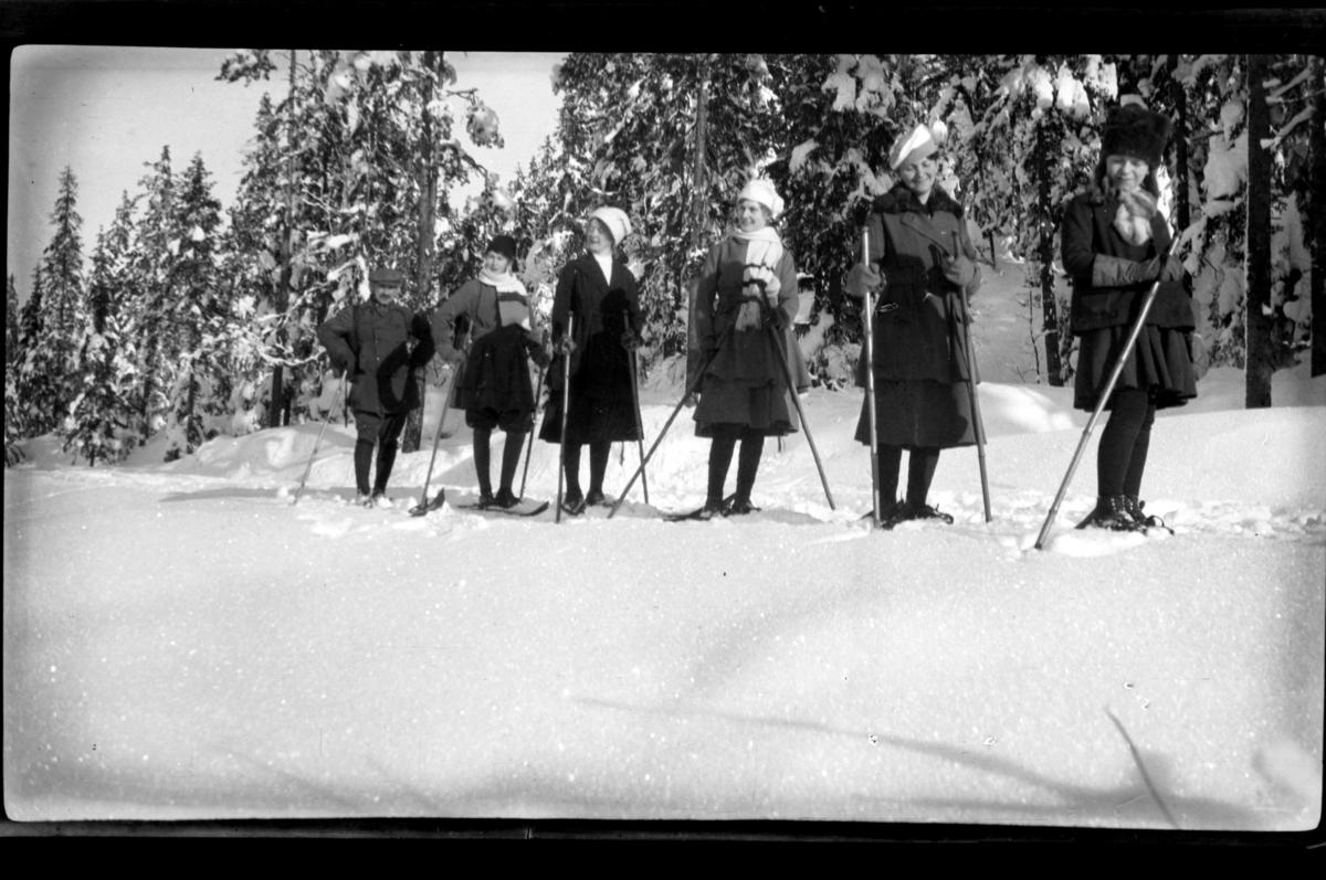Fem voksne og en ung pike på ski i Voksenkollen, Oslo. Fra venstre Louis Jersin, Birgit Aubert, ukjent kvinne, Hilda Sundt, Sigrid og Esther Jersin. Fotografert 1919.