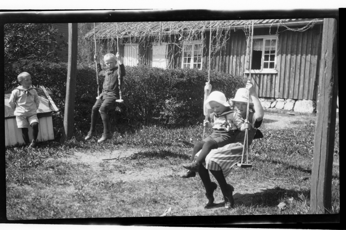 Ukjent gutt, Bjarne Halfdanssøn Sundt, Julius Sundt og Julie Cecilie (Essemor) Sundt sitter på husker, Stavern. Fotografert 1920.