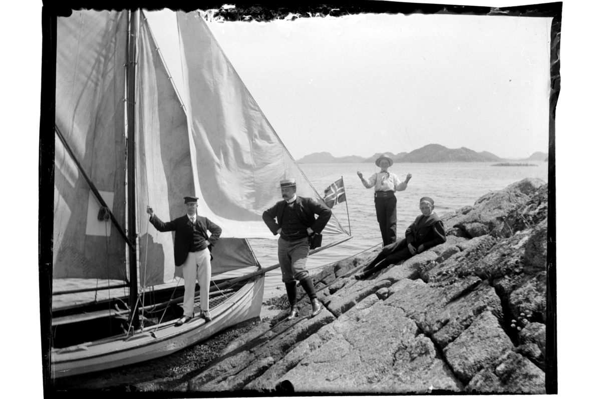 Brødrene Rolf Sr., Leif, Lauritz og Peter B.D. Sundt har lagt til med seilbåt ved Spindslandet mot Midtfjordskjær. Antagelig fotografert 1902.
