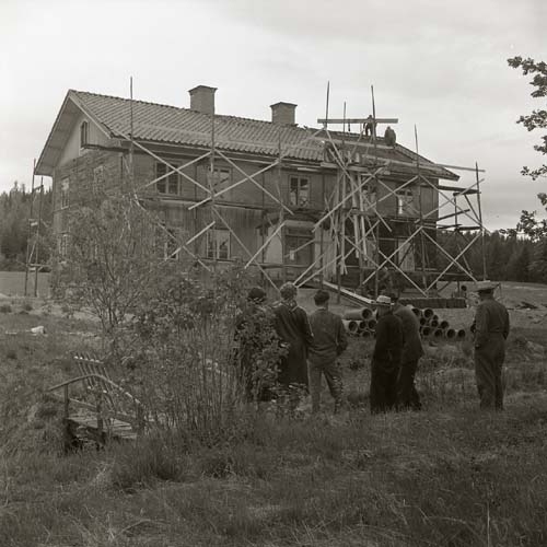 Lassekrog med trädgård. Byggnadsställningarna är uppe och man lägger taket,  4 juni 1963.