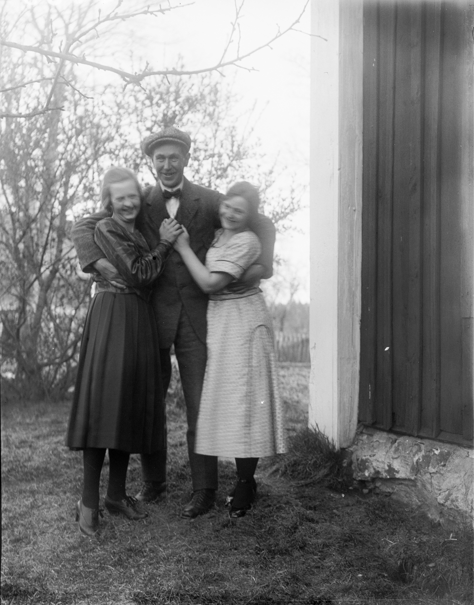 Klara Nilsson, Anton Johanson och Elsa Alström står i trädgården i Sävasta, Altuna socken, Uppland 1922