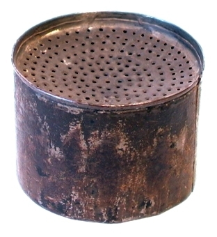Cylinderformad sanddosa av plåt med perforerad nedsänkt överdel. Dosan innehåller sand.