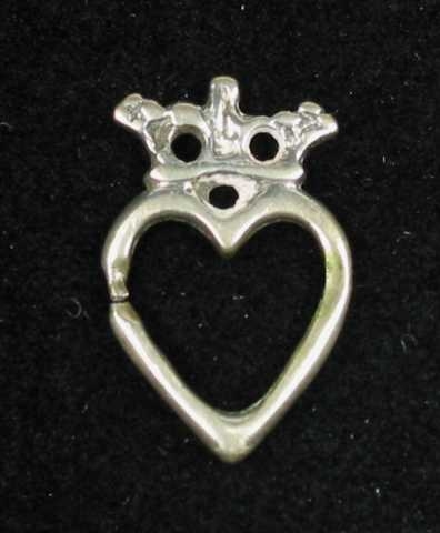 Lita støpt hjertesprette i sølv med krone. Det er tre hull i kronen som har en liten tapp øverst i midten. Tornen mangler. Ingen synlige stempel.