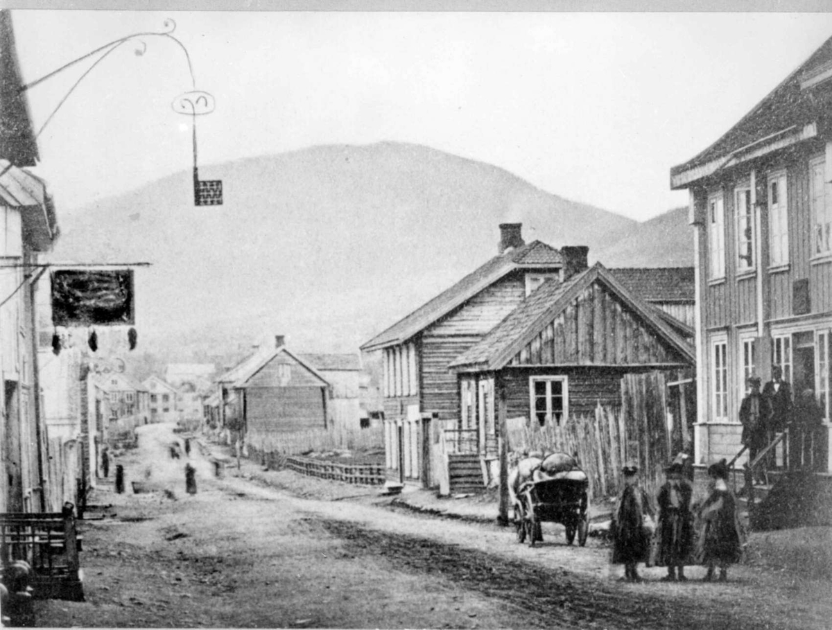 Repro: Lillehammer først på 1860-tallet, Storgata fra nr. 97 (til høyre) og nordover. Tomtegata er ennå ikke opparbeidet. Det lille huset er Storgata 101, hvor buntmaker Ring holdt til i mange år.