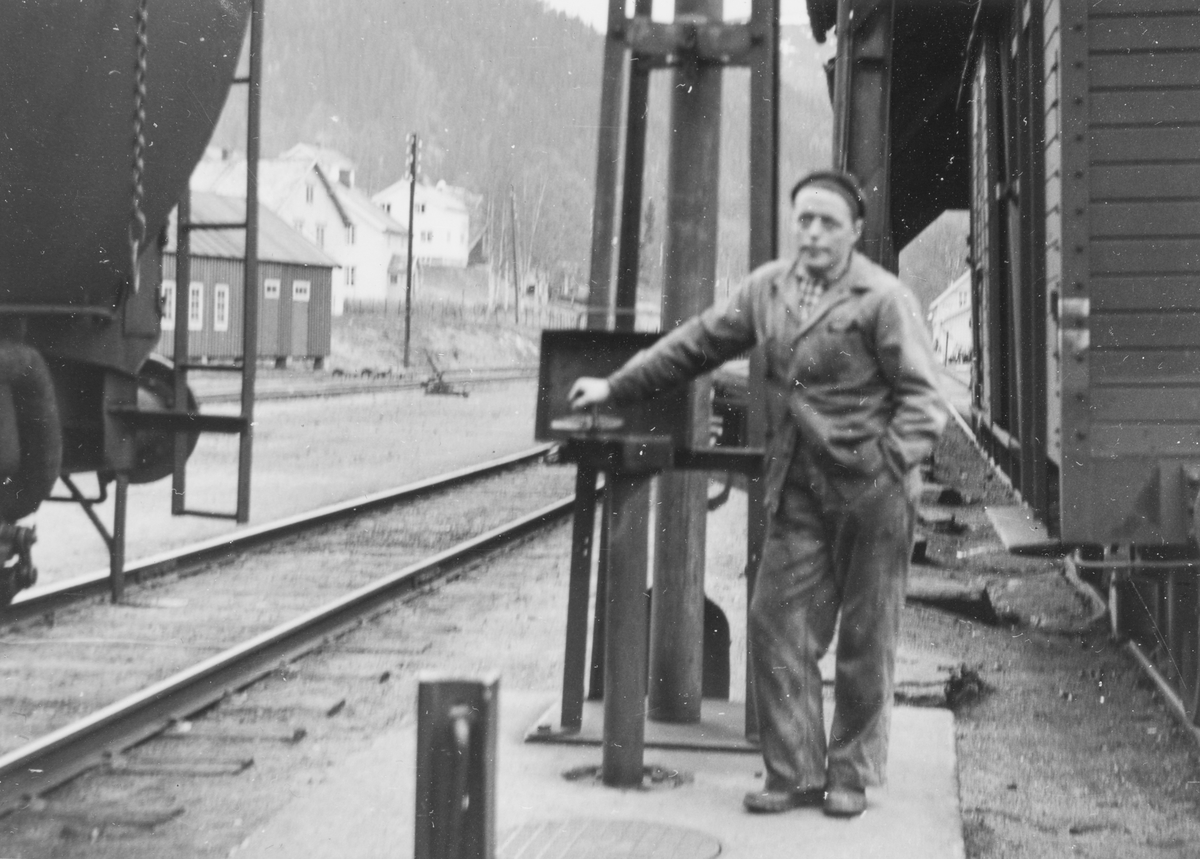 Lokomotivstallbetjent Ole Schjødt fyller vann på damplokomotiv type 63a.