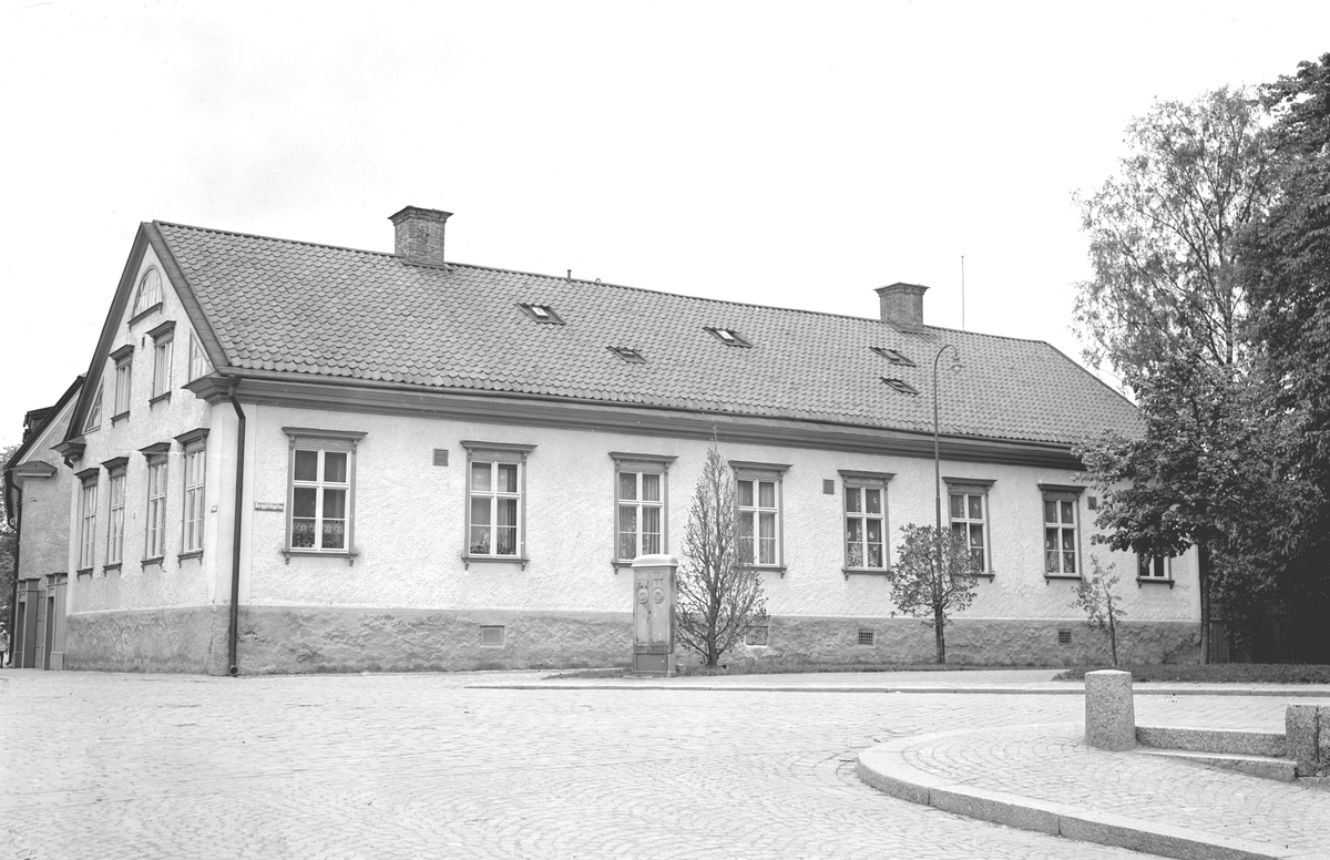 Domprostgården i Linköping omkring 1945. Byggnaden uppfördes i början av 1800-talet genom landskamrer Johan Olog Hertzmans försorg. År 1897 blev den domprostgård. Bilden visar fastighetens ursprungliga läge. År 1953 flyttades byggnaden några tiotal meter mot norr för att göra Storgatans breddning möjlig. Vy från öster.