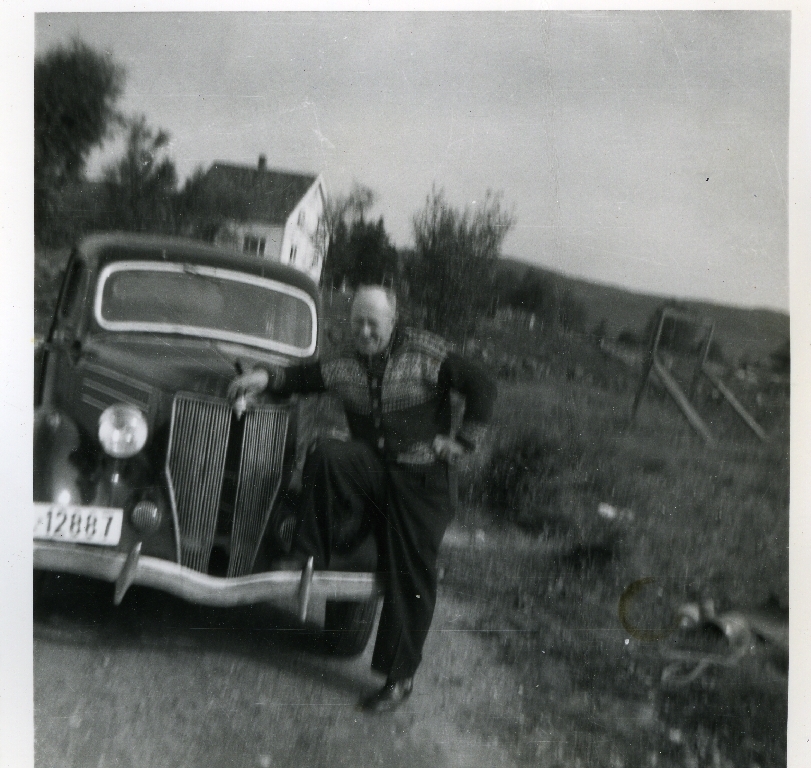 Ola Njå (27.5.1921 - 6.7.1999) framfor bilen sin ein Mercedes? 1952. I bakgrunnen er huset til Tormod Egeland (21.12.1908 - 25.8.1993)