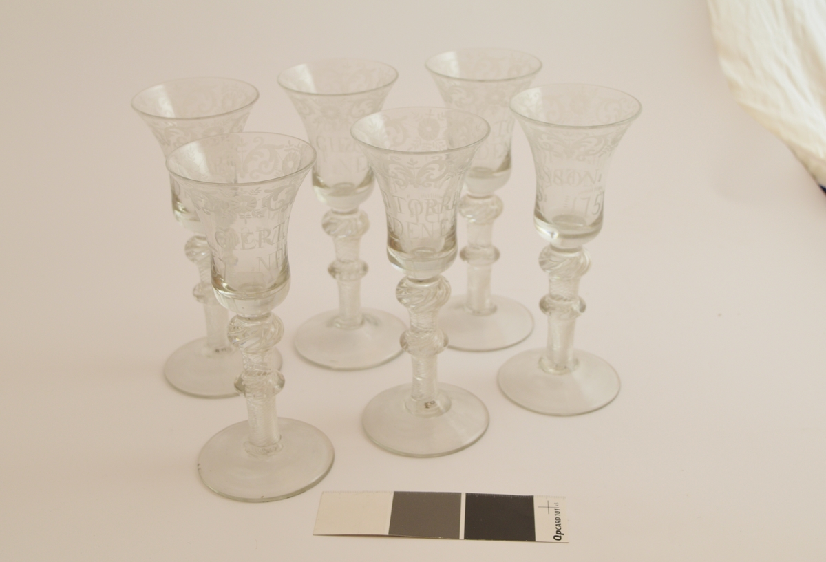 Seks glass. Rund fotplate, to runde former på stettet Klokken er smalnende midt på glasset og videst langs munningsranden.